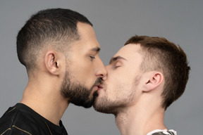 Close-up de dois homens caucasianos se beijando suavemente