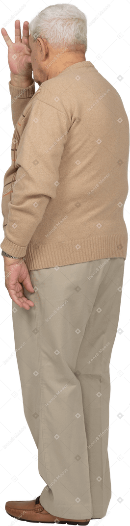 Seitenansicht eines alten mannes in freizeitkleidung, der durch die finger schaut