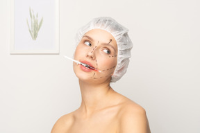 Jeune femme tenant une seringue entre les dents