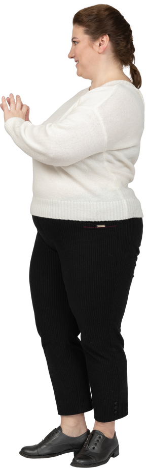 Donna grassoccia in maglione bianco che mostra la figura del cuore con le dita