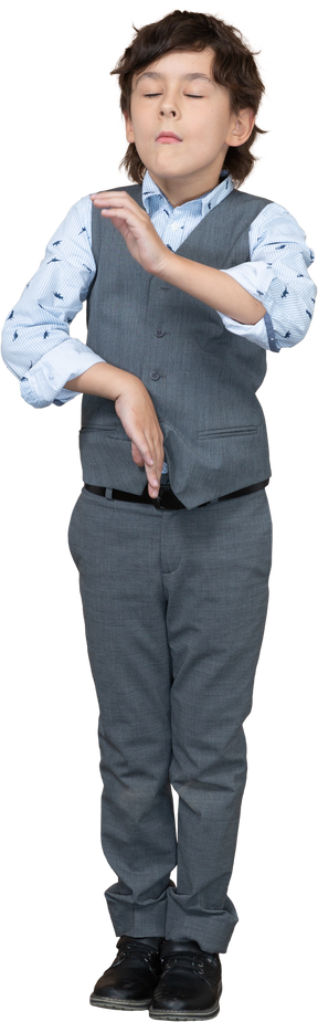 Front view of a boy in suit standing with closed eyes and gesturing