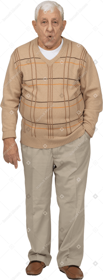Vista frontal de un anciano con ropa informal de pie con la mano en el bolsillo y mirando a la cámara