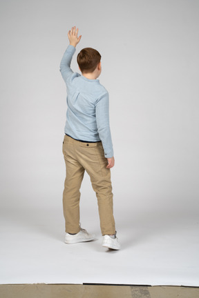 Back view of a boy waving