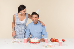 Joven pareja interracial celebrando el cumpleaños del hombre