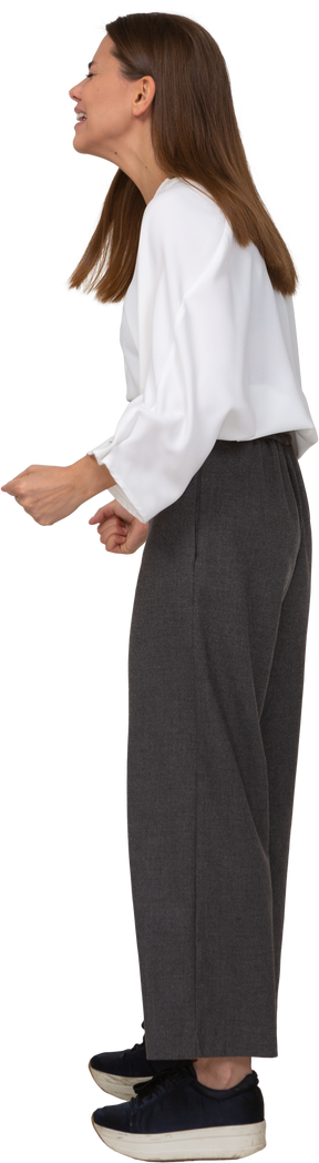 Side view of a crying young lady in office clothing clenching fists