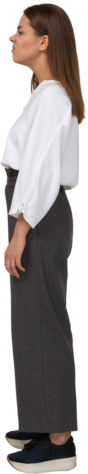 Side view of a displeased young lady in office clothing looking aside