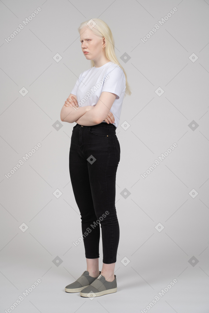 Vista di tre quarti di una ragazza bionda con le braccia conserte