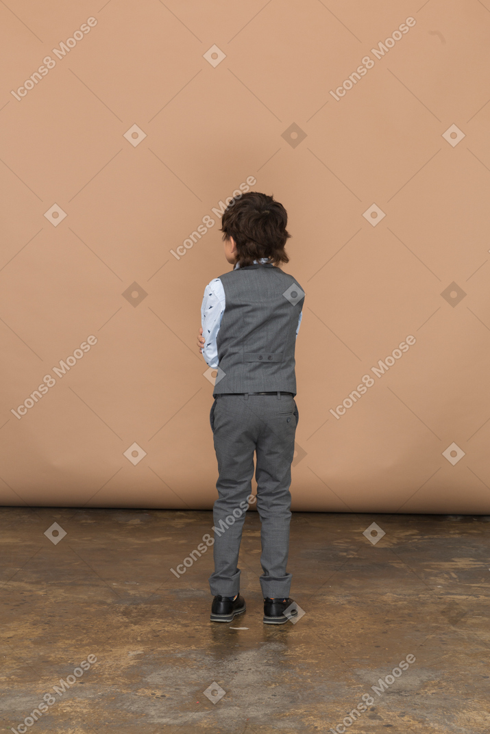 Vista posteriore di un ragazzo vestito di grigio