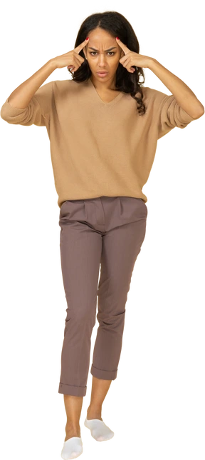 Front view of a dark-skinned young female touching her temples