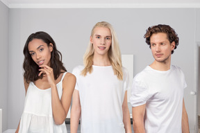 Three people in white clothes standing in a room