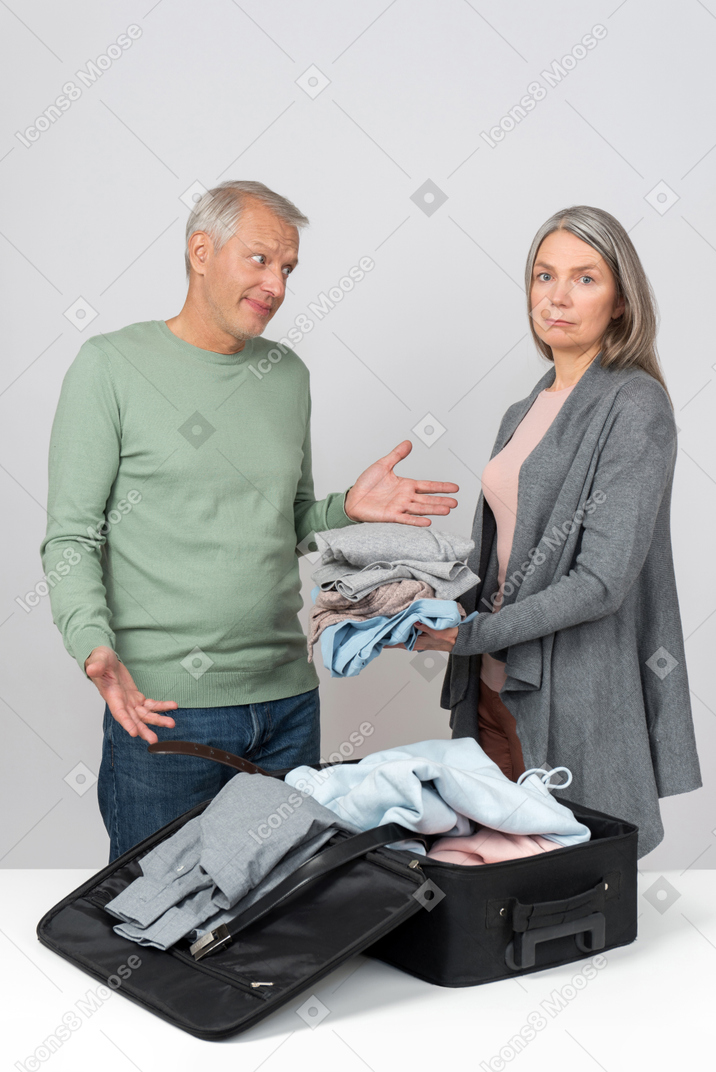 Middle aged couple packing a suitcase