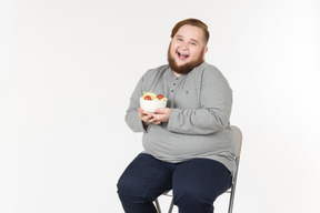 Riendo hombre barbudo grande con plato de ensalada