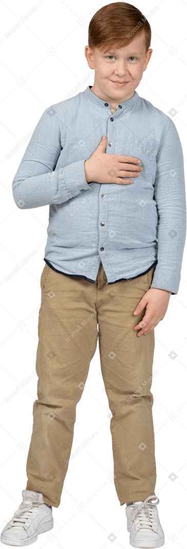 Front view of a cute boy standing with hand on chest and looking at camera
