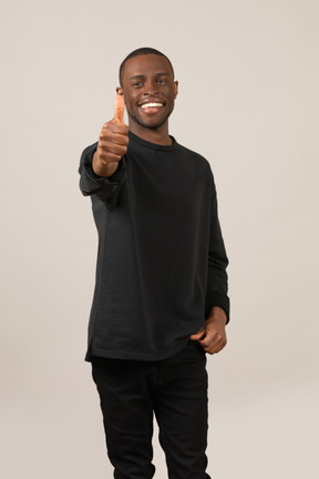 Happy young man showing thumb up
