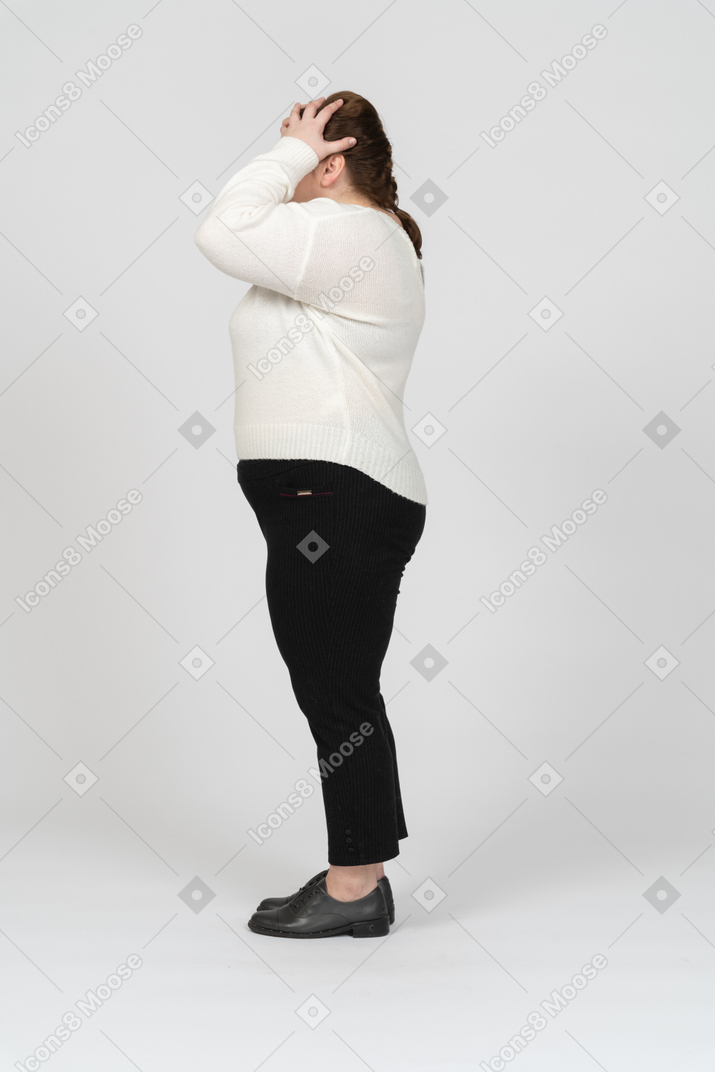 Plus size woman in white sweater suffering from headache