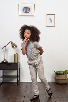 Good looking girl kid posing on the apartment background