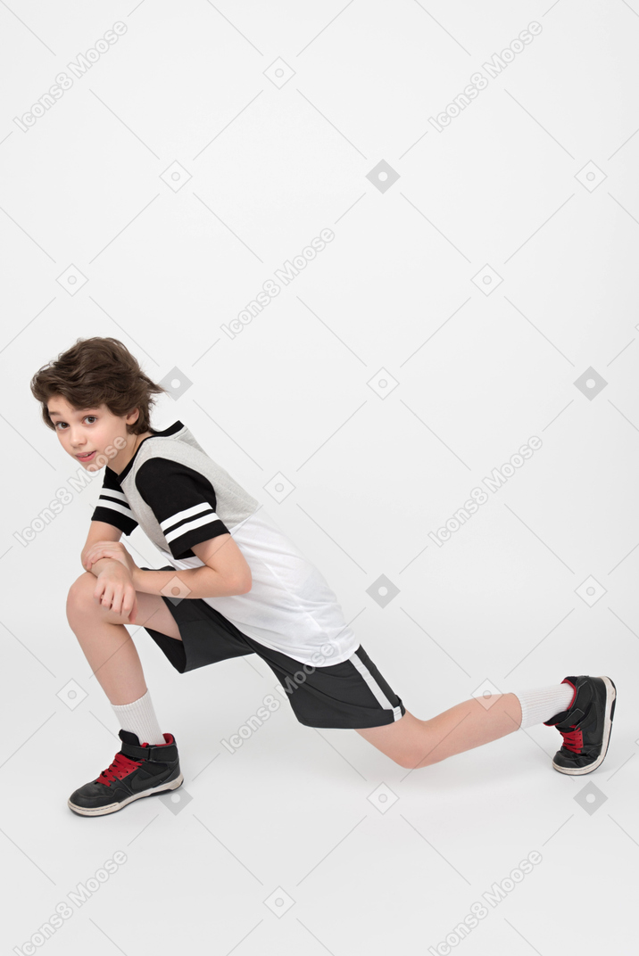 Ragazzo bambino atletico facendo un allungamento
