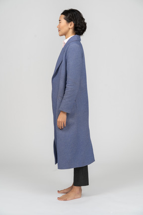 Side view of a woman with closed eyes wearing blue coat