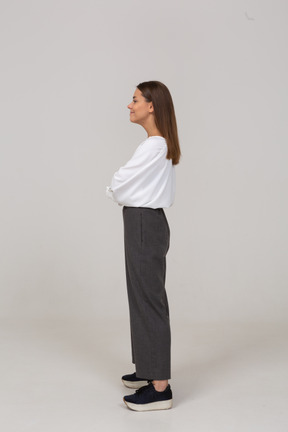 Side view of a smiling young lady in office clothing looking aside