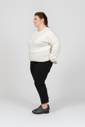 Plump woman in casual clothes standing in profile