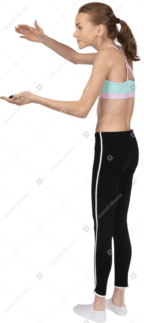 Side view of a surprised teen girl in sportswear raising hands