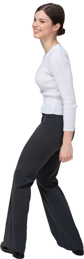 Three-quarter back view of a delighted smiling young woman in office clothing