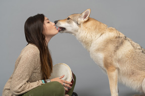 Lindo cão de raça pura beijando uma jovem mulher