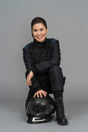 Una giovane donna sorridente che si siede con un casco