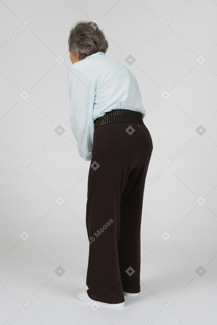 Three-quarter back view of old woman leaning down