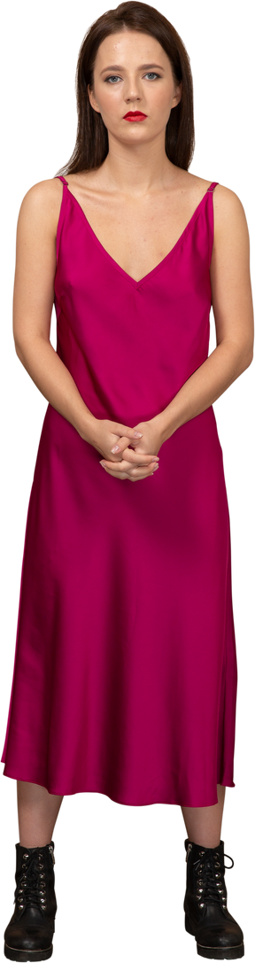 一个穿着漂亮红色连衣裙的年轻女子看着相机的前视图