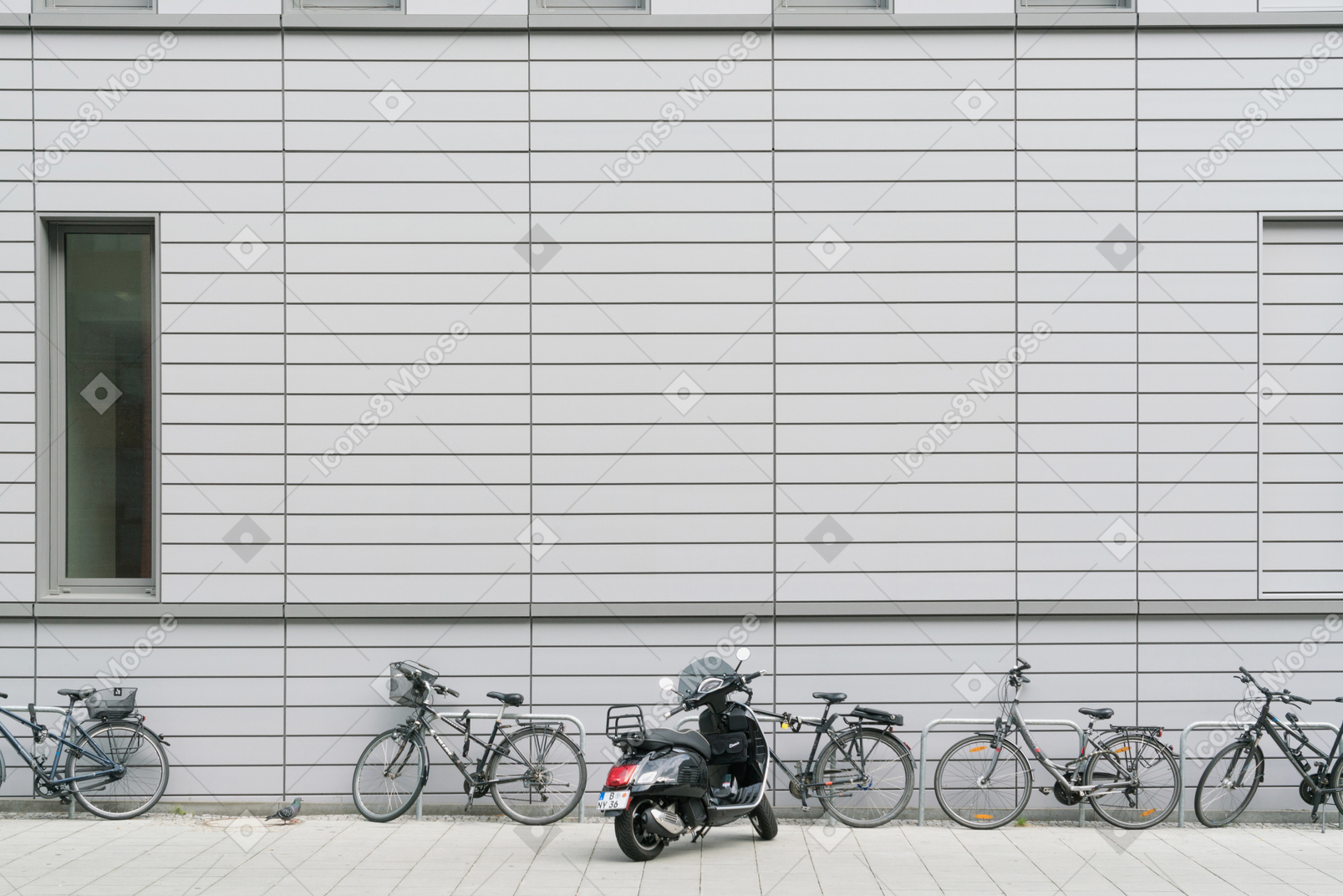 Bicicletas e scooters estacionados em frente ao prédio