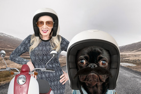 Черная собака в шлеме и женщина с мопедом