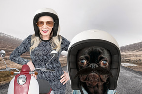 Schwarzer hund im helm und frau mit moped