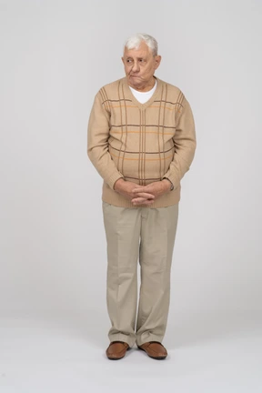 Front view of an old man in casual clothes making faces