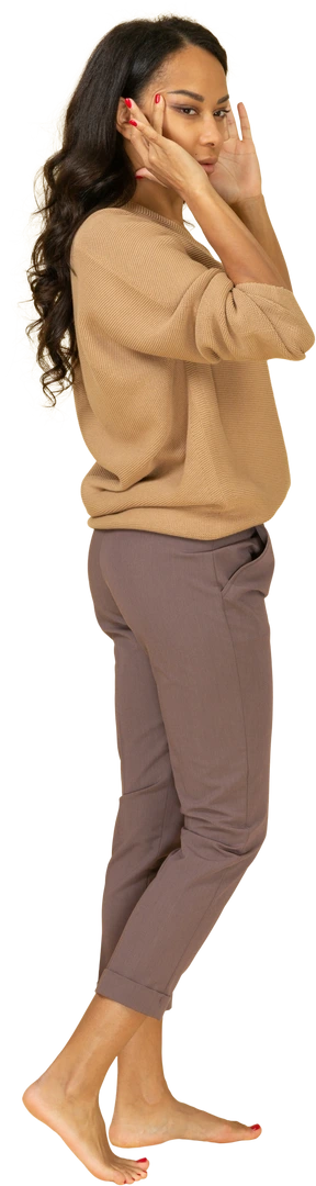 Three-quarter back view of a young dark-skinned female narrowing her eyes