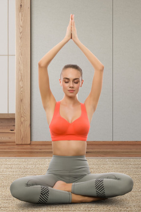 A woman in a red top is doing yoga