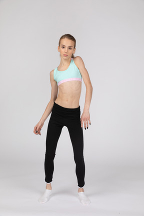 Vista frontale di una ragazza adolescente in abiti sportivi inclinando le spalle