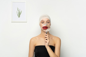 Young woman holding magnifier over her mouth