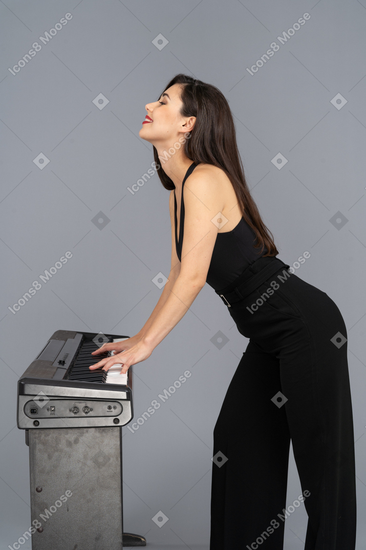 Mulher sorridente, desfrutando de tocar piano