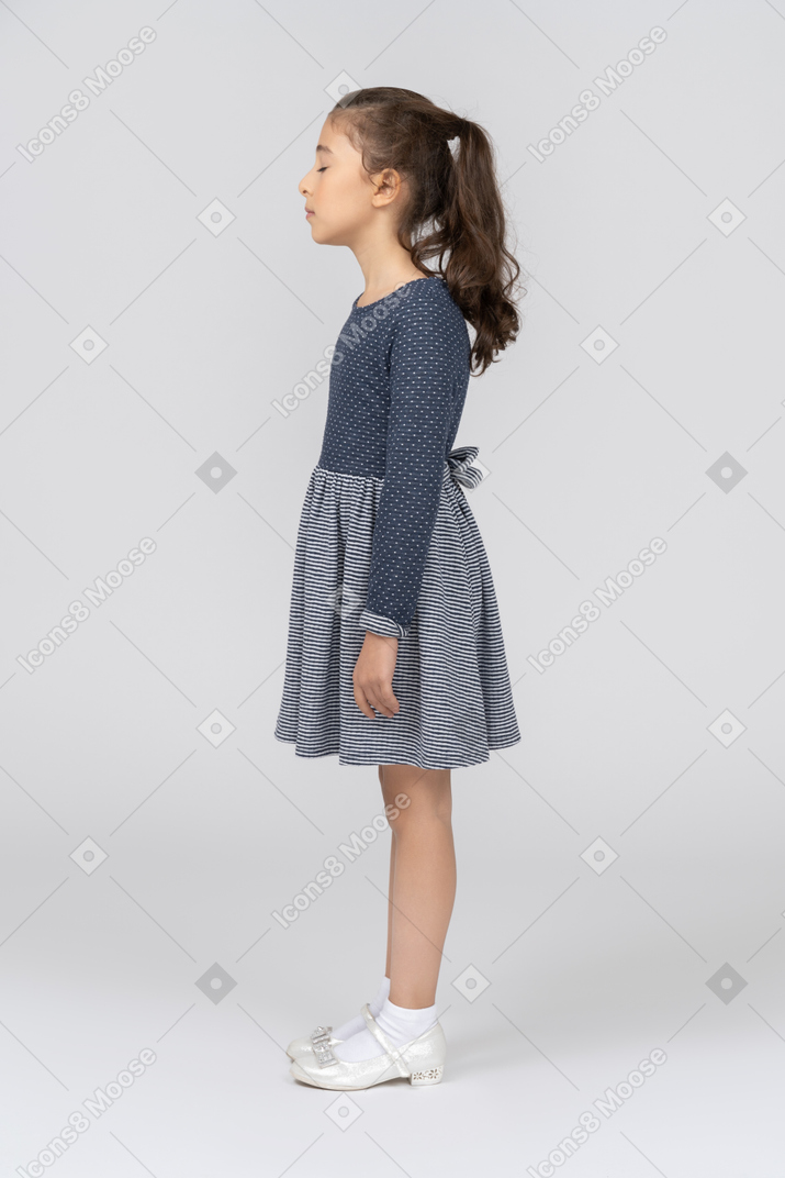 Vista lateral de uma garota em roupas casuais com os olhos fechados