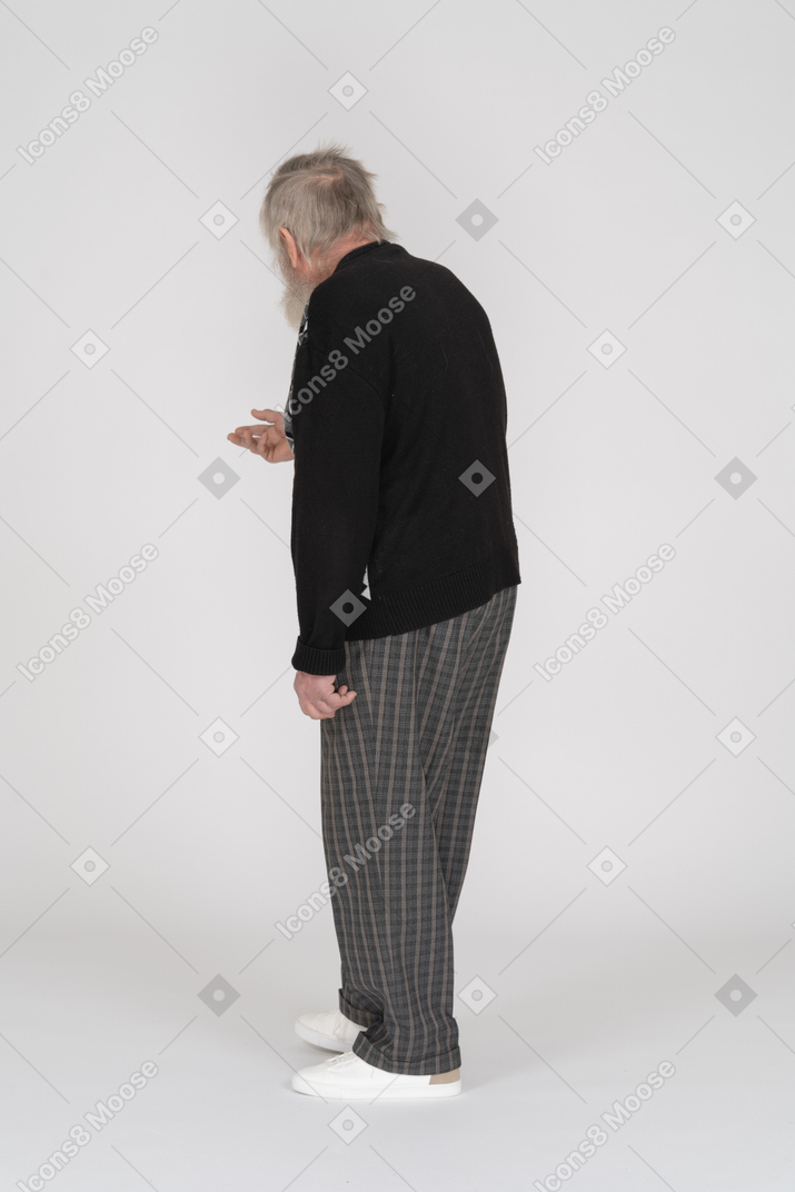 Side view of an elderly man reaching out his hand