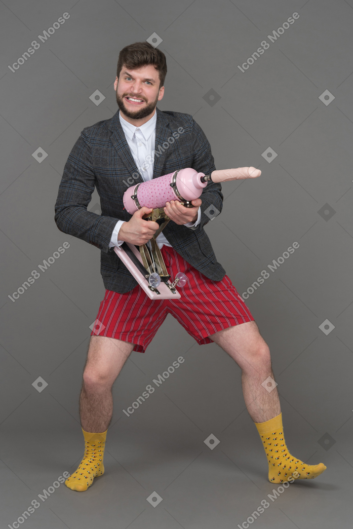 Man posing with sex machine holding it like a gun