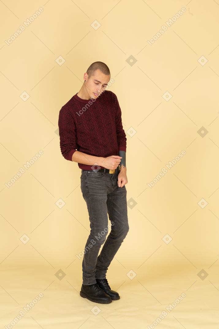 Three-quarter view of a tired dancing young man in red pullover