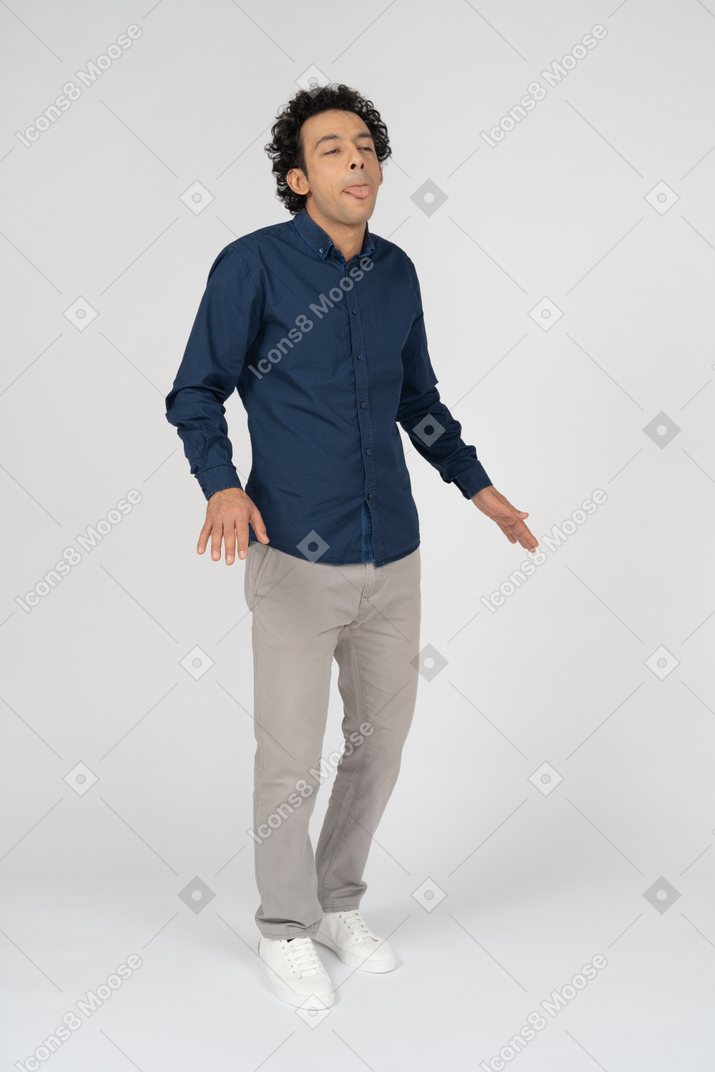 Vista frontale di un uomo in abiti casual che mostra la lingua