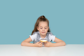 Niña linda mirando un donut