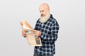 Bearded man reading a newspaper