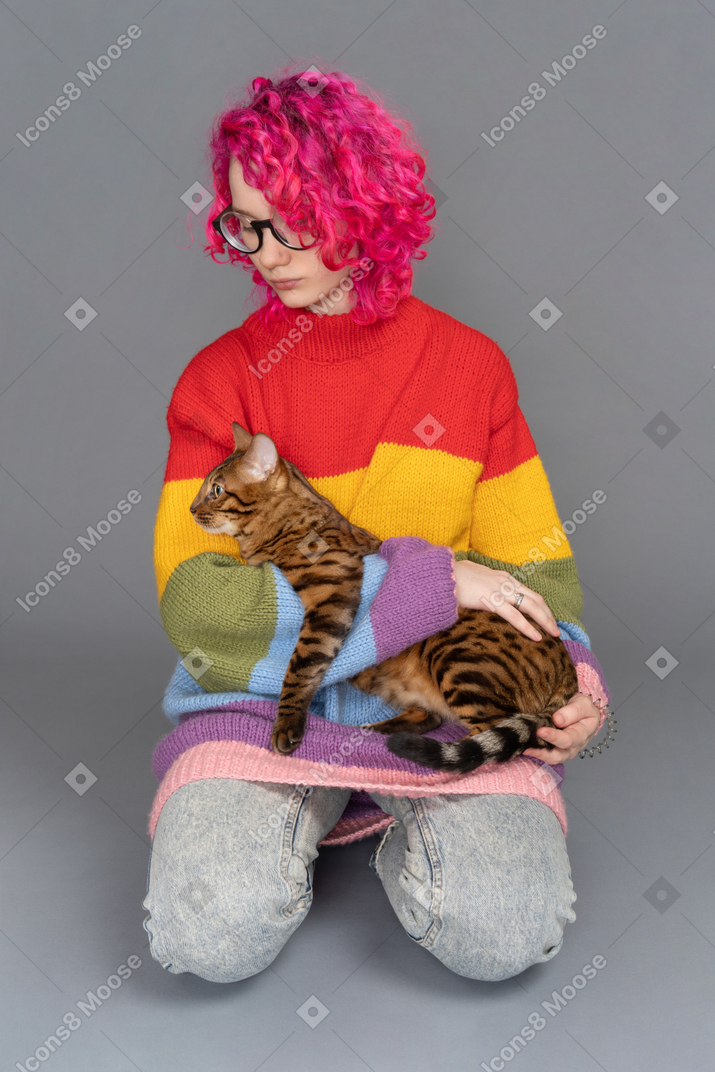 Mignon chat bengal assis aux mains du propriétaire