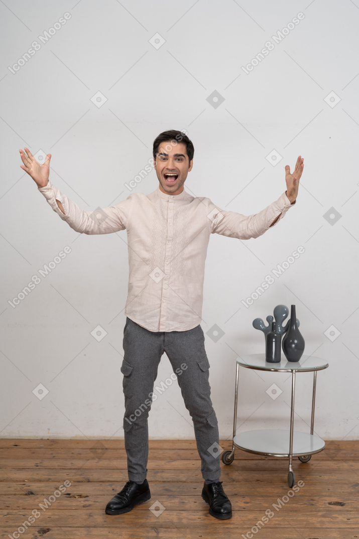 Front view of a happy man in casual clothes gesturing