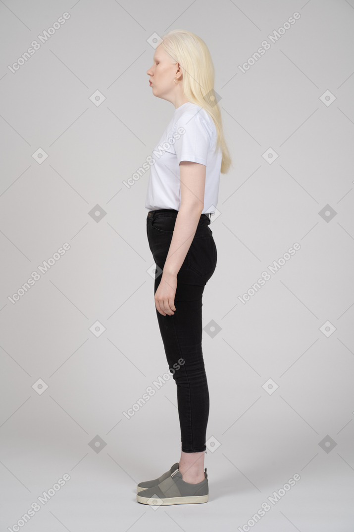 Vista lateral de uma mulher em pé com uma expressão facial neutra