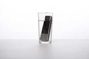 Téléphone portable dans un verre d'eau